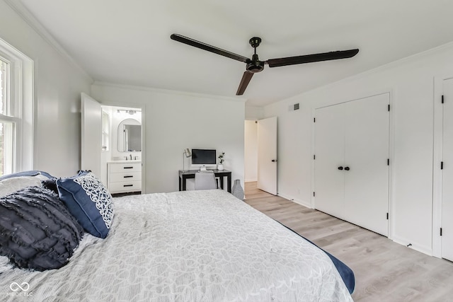 bedroom with crown molding, light wood-type flooring, connected bathroom, and ceiling fan