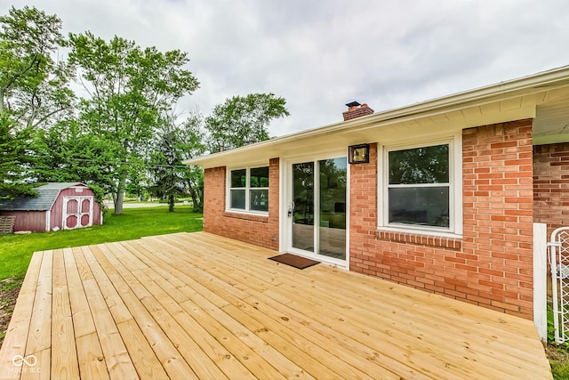 wooden deck with a shed and a lawn