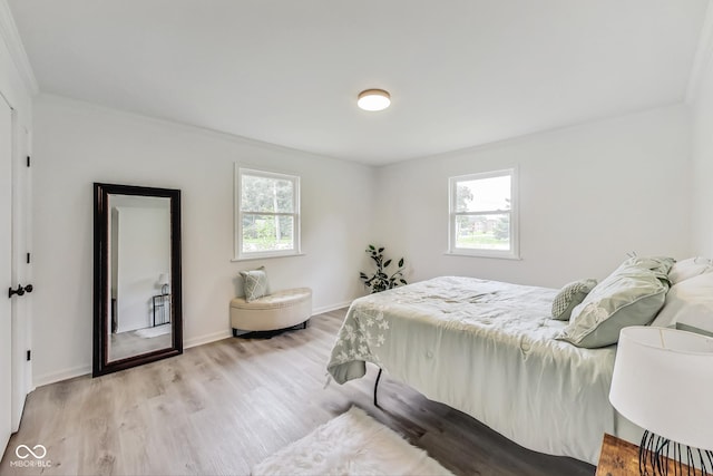 bedroom with multiple windows and light hardwood / wood-style flooring