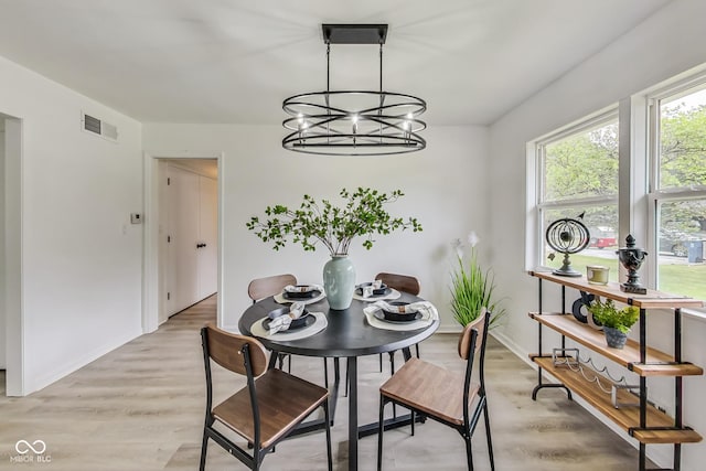 dining area with a notable chandelier and light wood-type flooring