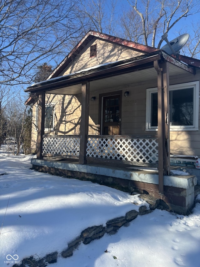 view of snow covered exterior featuring a porch