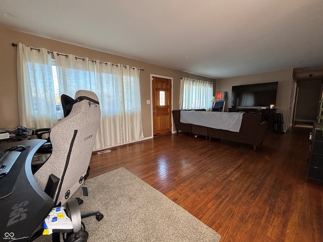 office with plenty of natural light and dark hardwood / wood-style floors