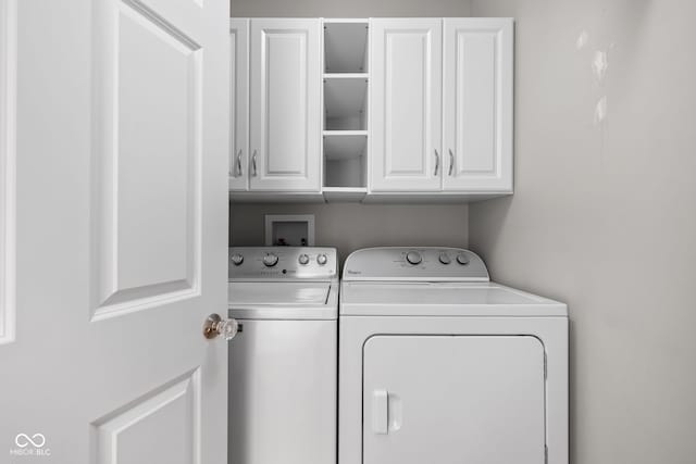 washroom featuring cabinets and separate washer and dryer