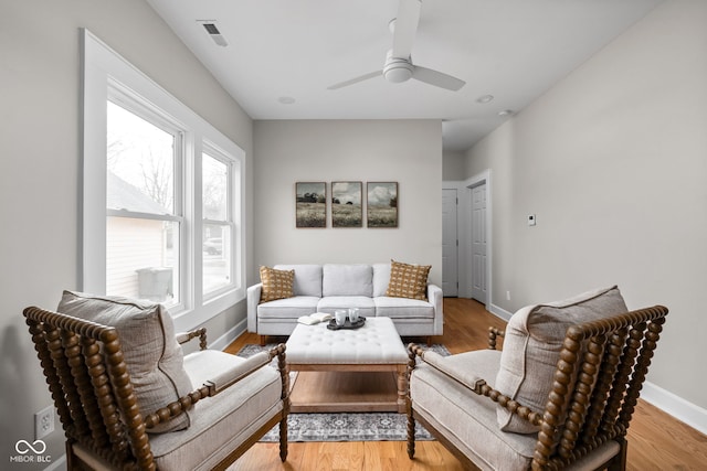 living room with ceiling fan and light hardwood / wood-style flooring