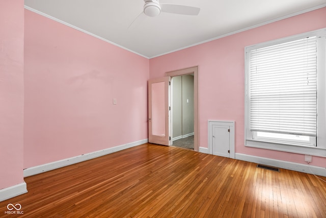 empty room featuring wood-type flooring, ornamental molding, and ceiling fan