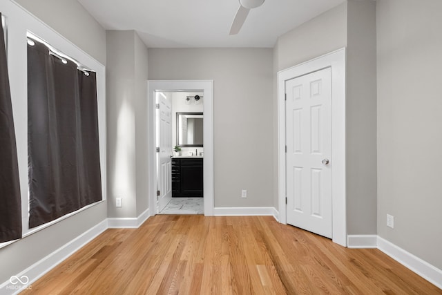 unfurnished bedroom with ensuite bathroom and light wood-type flooring