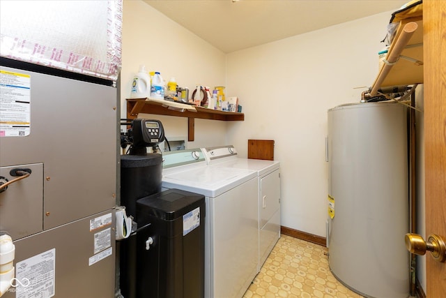 washroom featuring water heater, heating unit, and washer and clothes dryer