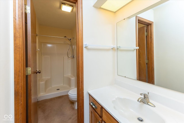 bathroom with vanity, toilet, and a shower