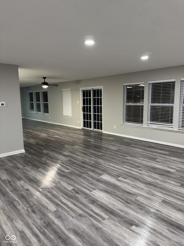 unfurnished living room featuring dark hardwood / wood-style floors and ceiling fan