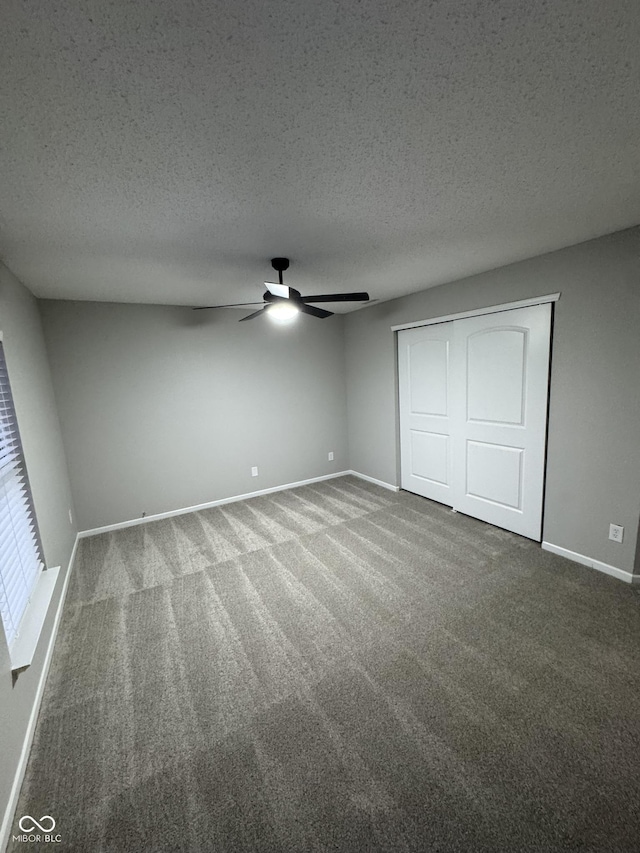 unfurnished bedroom featuring carpet, a textured ceiling, and a closet