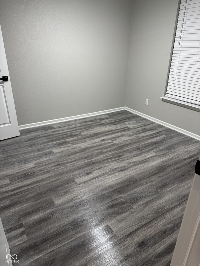 unfurnished room featuring dark wood-type flooring