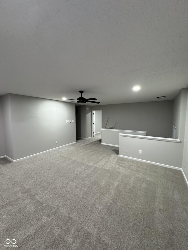 unfurnished living room featuring ceiling fan, a textured ceiling, and carpet flooring