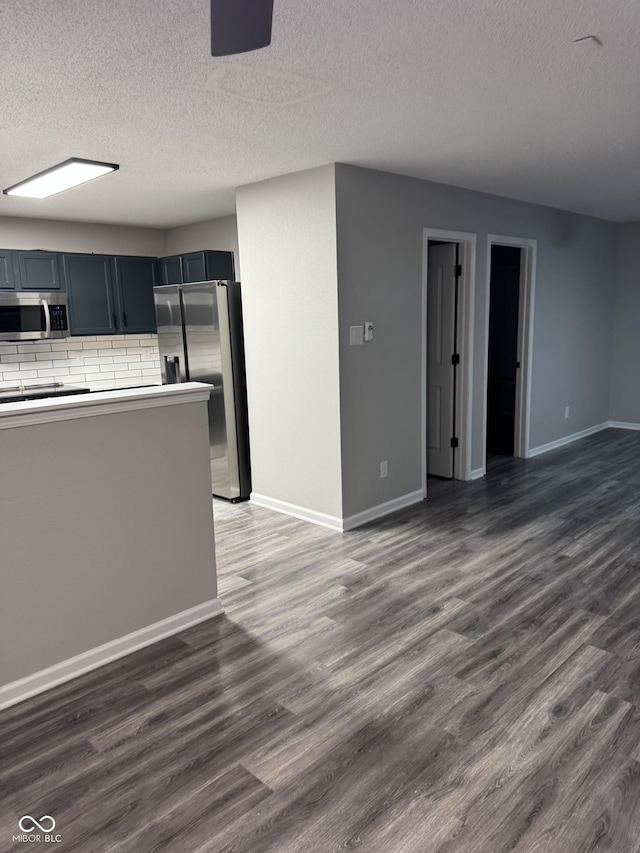 kitchen with dark hardwood / wood-style flooring, stainless steel appliances, and a textured ceiling