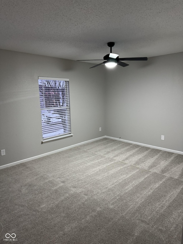 carpeted empty room with ceiling fan and a textured ceiling