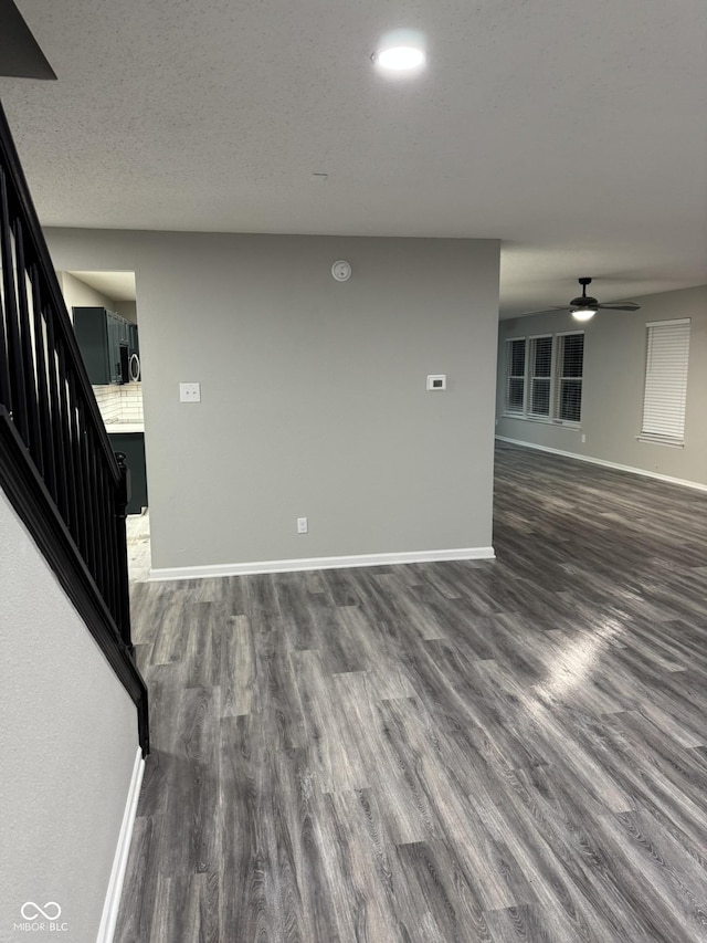 unfurnished room featuring ceiling fan, dark hardwood / wood-style floors, and a textured ceiling