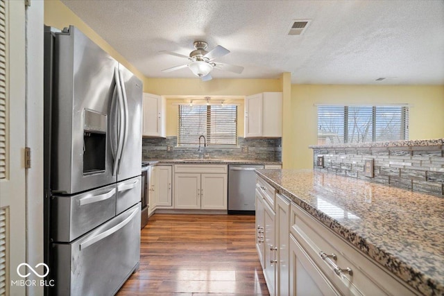 kitchen with sink, plenty of natural light, stainless steel appliances, and white cabinets