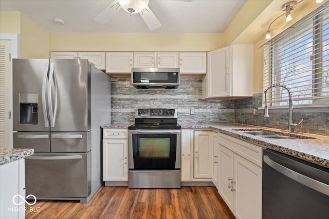 kitchen featuring stainless steel appliances, white cabinetry, sink, and light stone counters