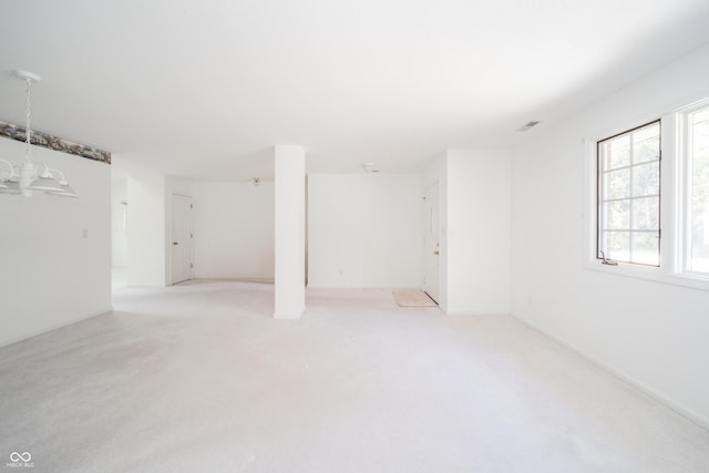 basement featuring light colored carpet and a chandelier