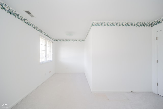 unfurnished room featuring light colored carpet