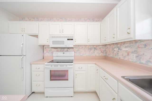 kitchen with white appliances, sink, and white cabinets