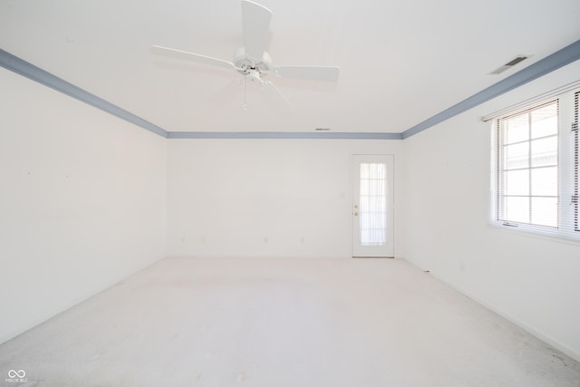 empty room featuring ceiling fan, ornamental molding, and carpet floors