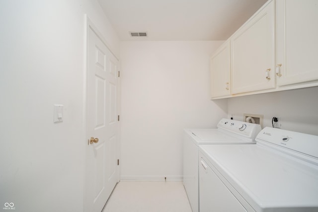 laundry room with cabinets and washer and clothes dryer