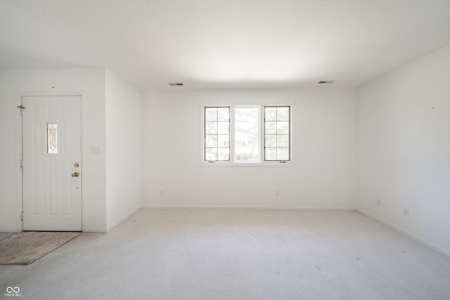 spare room featuring light carpet