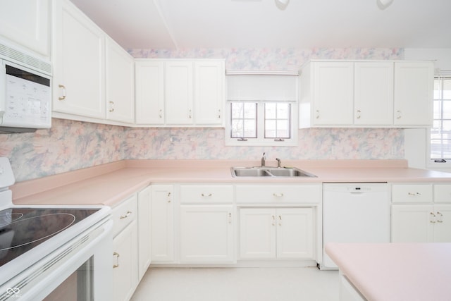 kitchen featuring white appliances, sink, and white cabinets