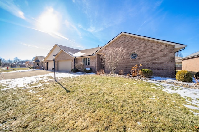 ranch-style house featuring a garage and a front lawn