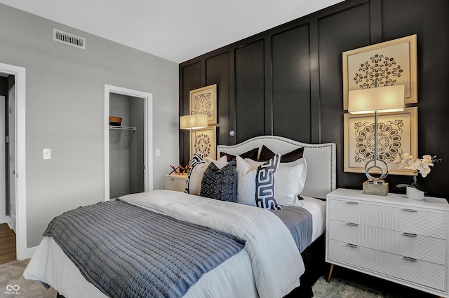 bedroom with dark carpet and a spacious closet