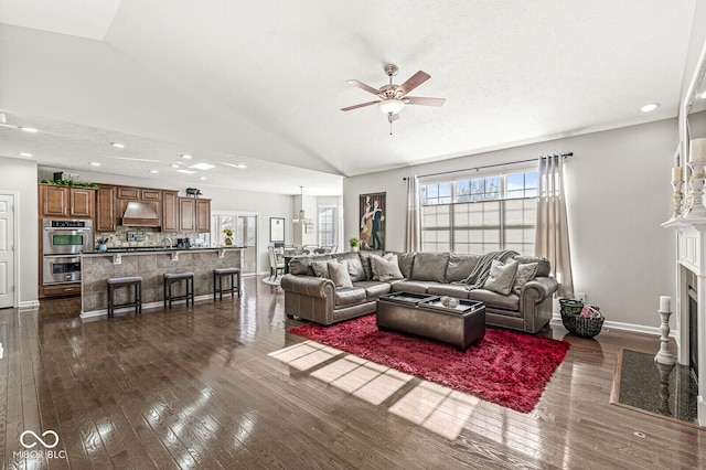 living room with ceiling fan, a healthy amount of sunlight, dark hardwood / wood-style flooring, and vaulted ceiling