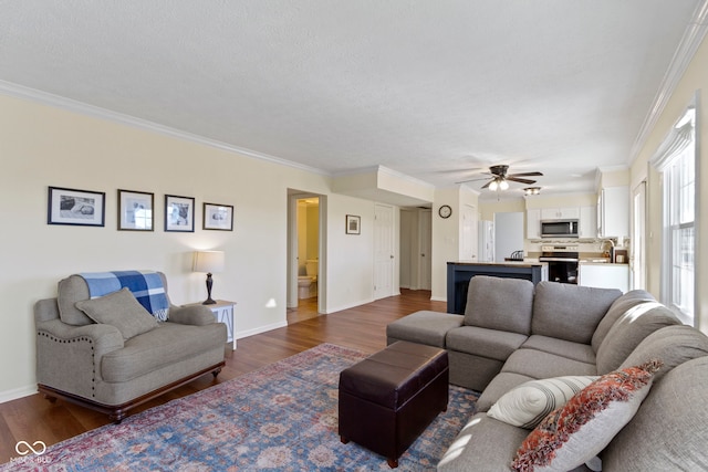 living room featuring crown molding, dark hardwood / wood-style floors, a textured ceiling, and ceiling fan