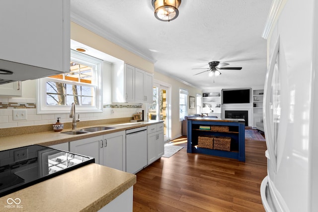 kitchen featuring ornamental molding, sink, white cabinets, and white appliances