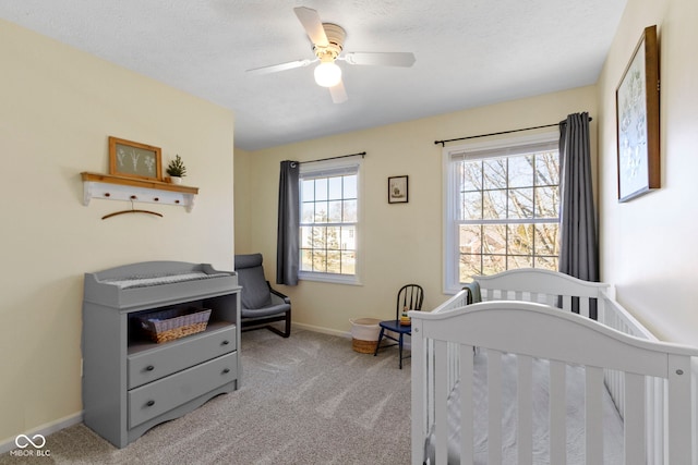 carpeted bedroom with ceiling fan, multiple windows, and a textured ceiling