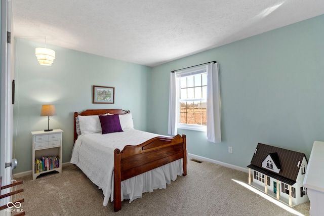 bedroom with light colored carpet and a textured ceiling