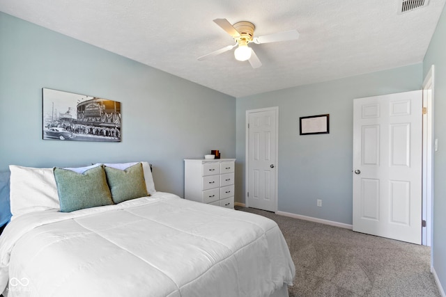 bedroom featuring light colored carpet, a textured ceiling, and ceiling fan