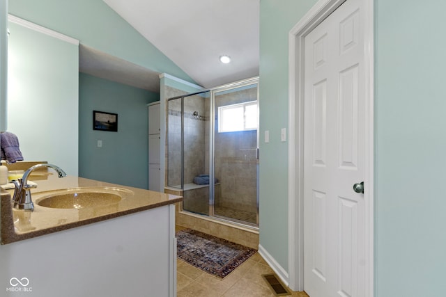 bathroom with tile patterned floors, vanity, a shower with shower door, and vaulted ceiling