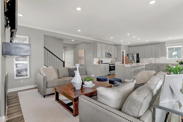 living room with crown molding and light hardwood / wood-style floors