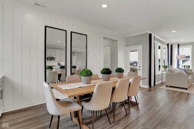 dining area featuring ornamental molding and hardwood / wood-style floors