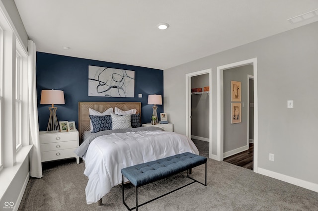 bedroom featuring a walk in closet, a closet, and carpet