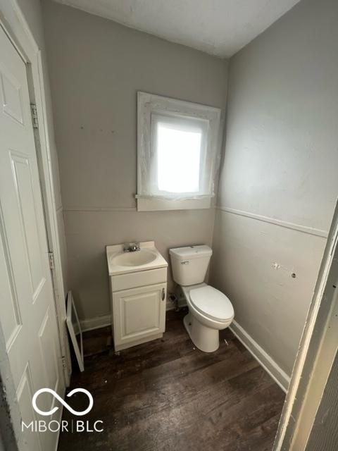 bathroom with wood-type flooring, vanity, and toilet