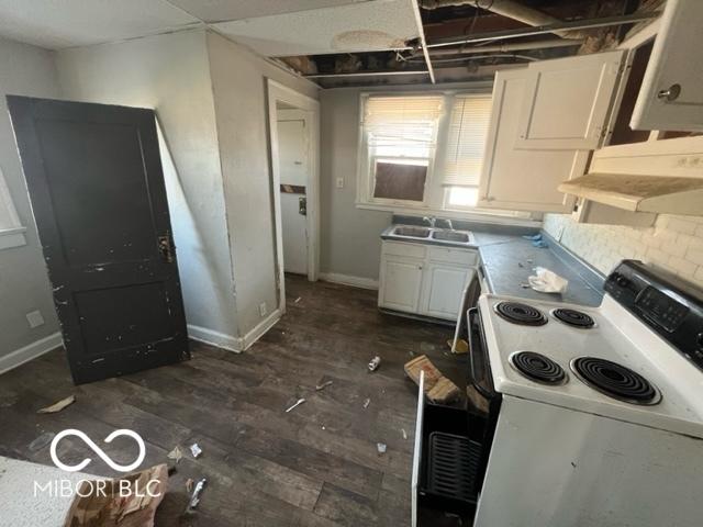 kitchen with dark wood-type flooring, white electric stove, sink, and white cabinets