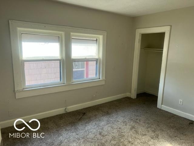 unfurnished bedroom featuring light carpet and a closet