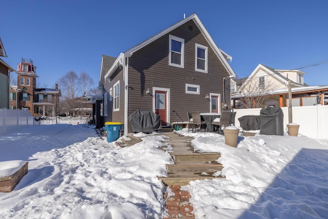 view of snow covered rear of property