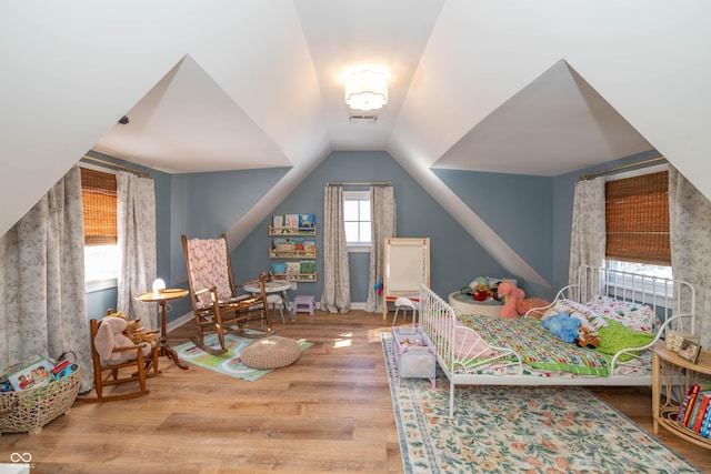 bedroom with lofted ceiling and wood-type flooring