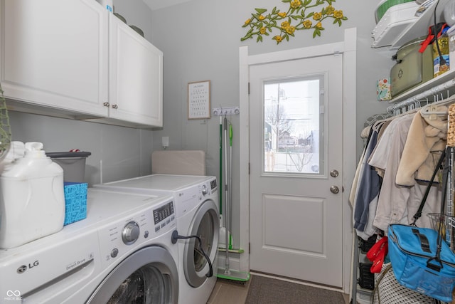 laundry area featuring washer and clothes dryer and cabinets