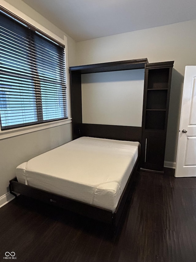 bedroom with dark hardwood / wood-style flooring