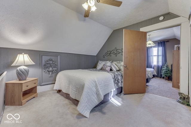 carpeted bedroom with ceiling fan, lofted ceiling, and a textured ceiling