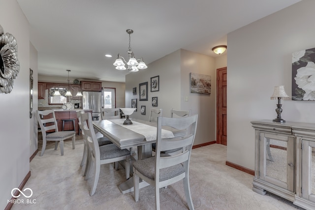 carpeted dining area featuring an inviting chandelier