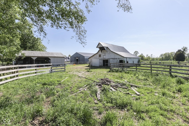 4462 S Morgantown Rd, Greenwood, IN 46143 - view of yard featuring a barn, an outbuilding, fence, and an exterior structure